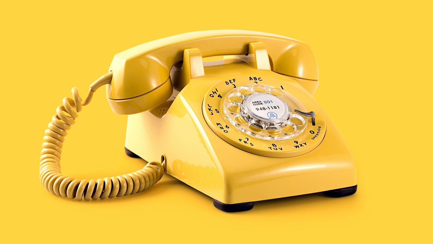 Yellow retro rotary telephone on warm background — landline phone nostalgia — The Rad Rewind