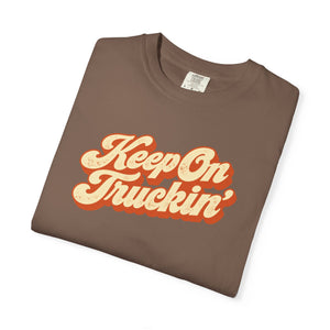 Espresso brown garment-dyed graphic tee with Keep On Truckin' in leaning cream script and a burnt-orange shadow, folded