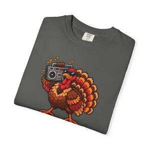 Pepper charcoal gray garment-dyed graphic tee with a pixel-art turkey in sunglasses carrying a boombox, folded