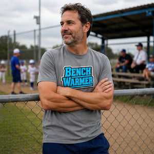 Lifestyle shot of The Rad Rewind Bench Warmer Tee — retro sports badge graphic in bold neon blue on a relaxed-fit garment-dyed tee