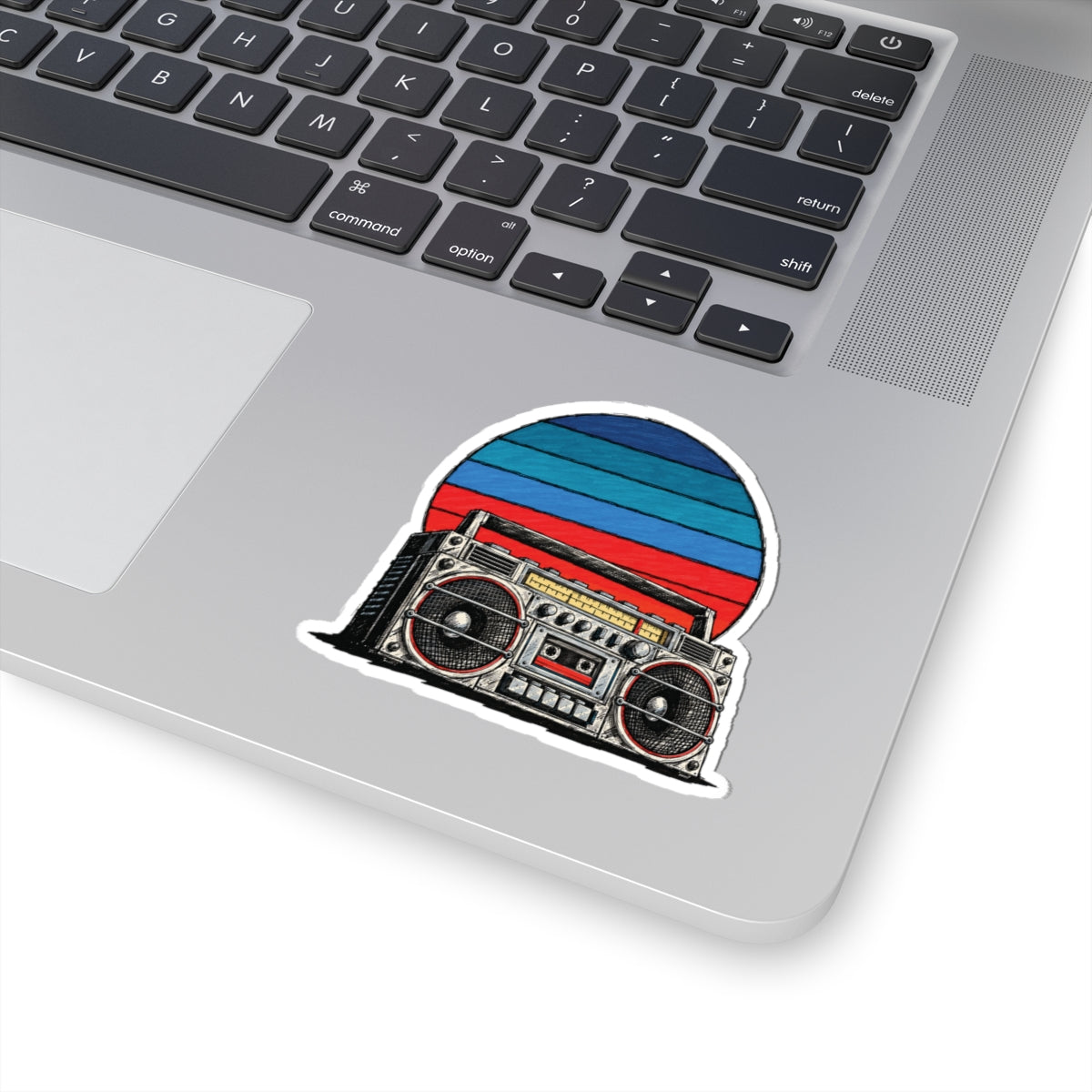 3 by 3 inch retro boombox sunset sticker applied to a laptop beside the keyboard