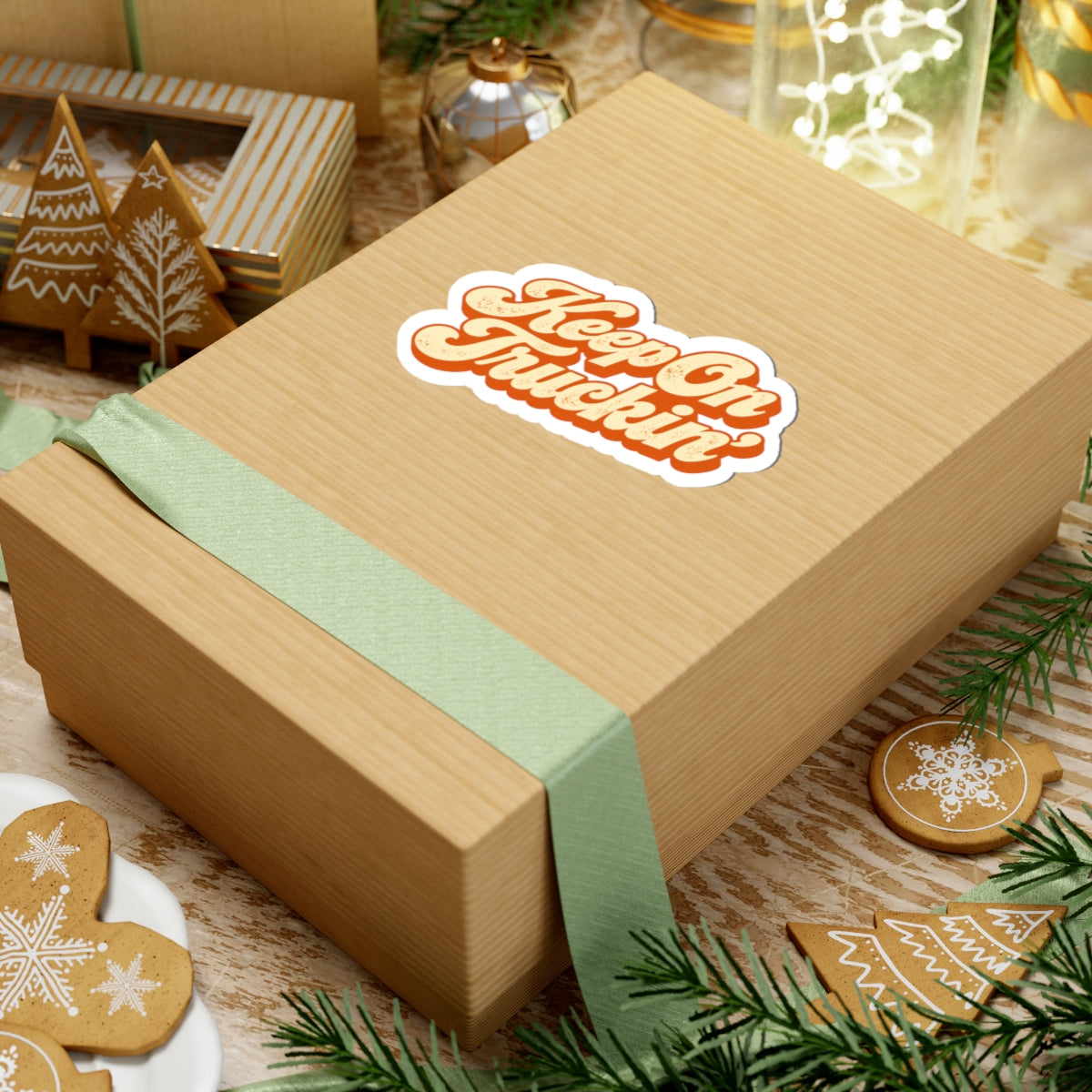 4 by 4 inch Keep On Truckin' retro script sticker applied to a kraft gift box among holiday decorations