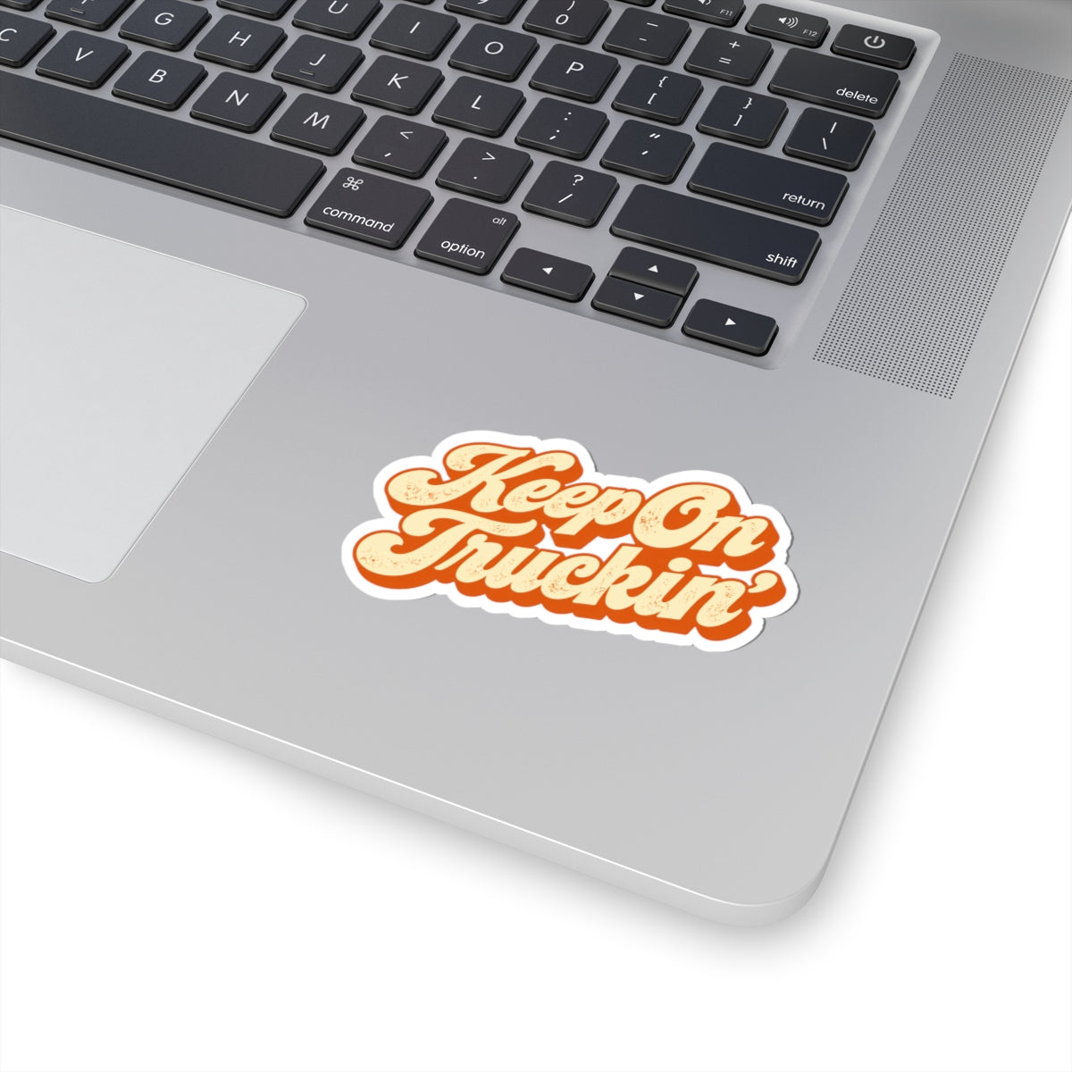 3 by 3 inch Keep On Truckin' retro script sticker applied to a laptop beside the keyboard