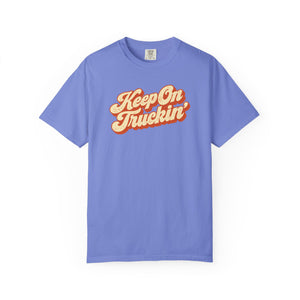 Flo Blue periwinkle garment-dyed graphic tee with Keep On Truckin' in leaning cream script and a burnt-orange shadow, front view