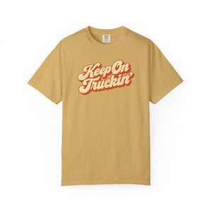 Mustard golden yellow garment-dyed graphic tee with Keep On Truckin' in leaning cream script and a burnt-orange shadow, front view