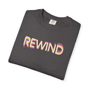 Graphite charcoal gray garment-dyed graphic tee with REWIND in retro echo-trail lettering trailing gold, pink and blue, folded