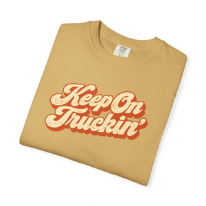 Mustard golden yellow garment-dyed graphic tee with Keep On Truckin' in leaning cream script and a burnt-orange shadow, folded