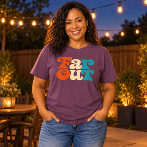Woman with long curly hair wearing the Berry Far Out graphic tee in a backyard at dusk under string lights