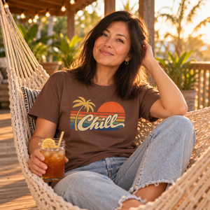 Smiling woman relaxing in a porch hammock with an iced tea, wearing the Espresso Chill graphic tee