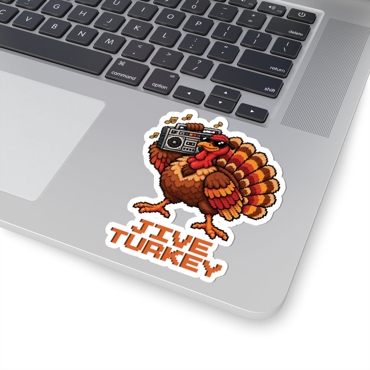 4 by 4 inch Jive Turkey pixel turkey sticker applied to a laptop beside the keyboard