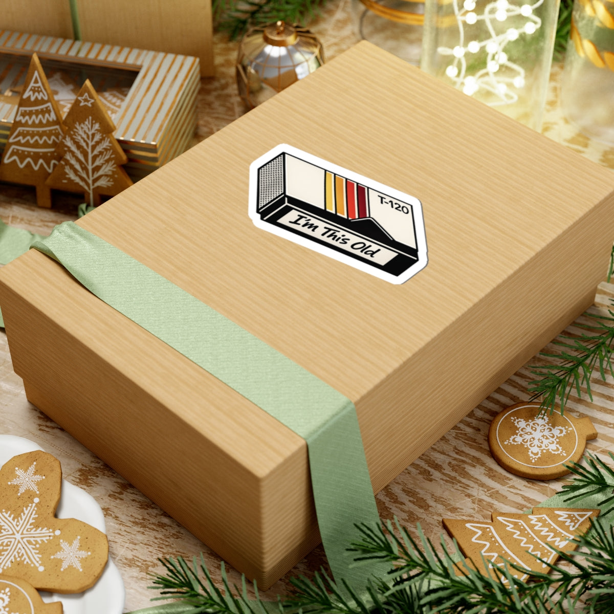4 by 4 inch I'm This Old retro VHS cassette sticker applied to a kraft gift box among holiday decorations