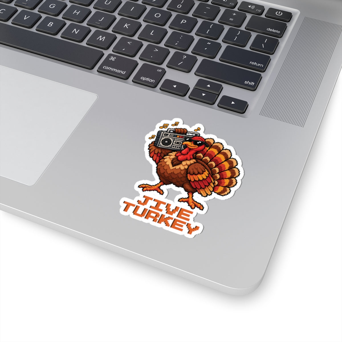 3 by 3 inch Jive Turkey pixel turkey sticker applied to a laptop beside the keyboard