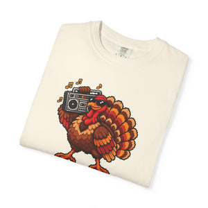 Ivory cream garment-dyed graphic tee with a pixel-art turkey in sunglasses carrying a boombox, folded