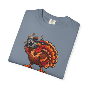Blue Jean slate blue garment-dyed graphic tee with a pixel-art turkey in sunglasses carrying a boombox, folded